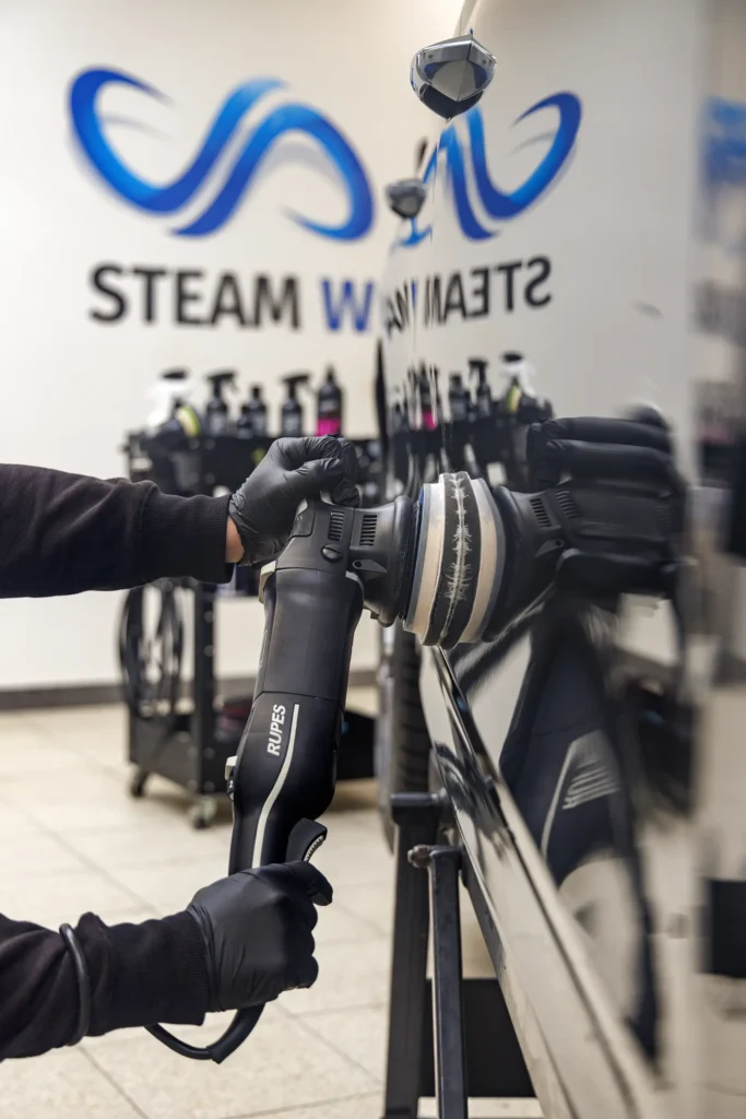 Ruční leštění laku automobilu pomocí profesionální leštičky v detailingovém studiu